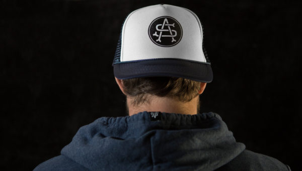 Product: "Monogram" Trucker Hat // Description: Foam Trucker mesh snapback hat with screen-printed logo // Color: Blue // Brand: The Angry Seas Clothing